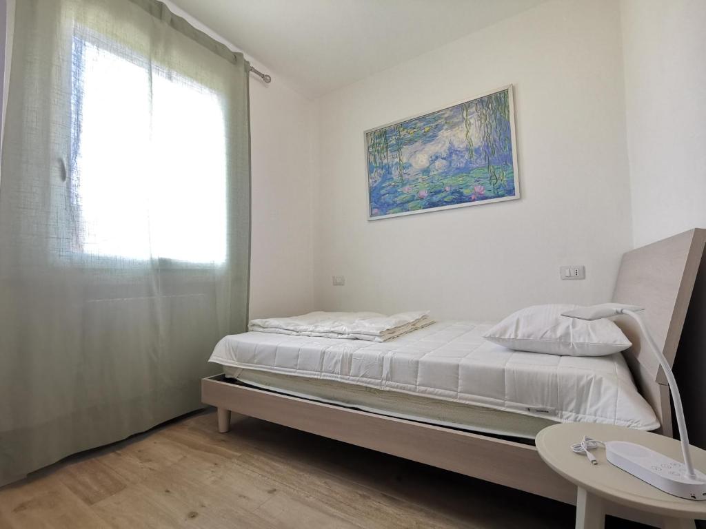 a white bedroom with a bed and a window at Casa Pina in Tignale