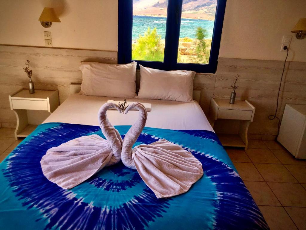 a bedroom with a bed with a heart shaped towel at Flisvos Rooms in Frangokastello