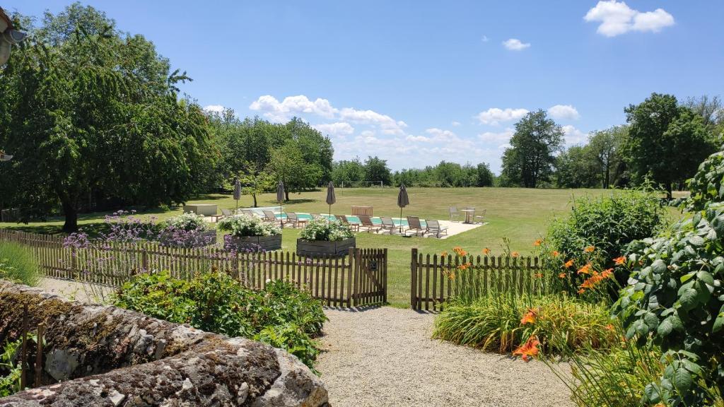 a garden with a wooden fence and some flowers at Manoir de Malagorse in Cuzance