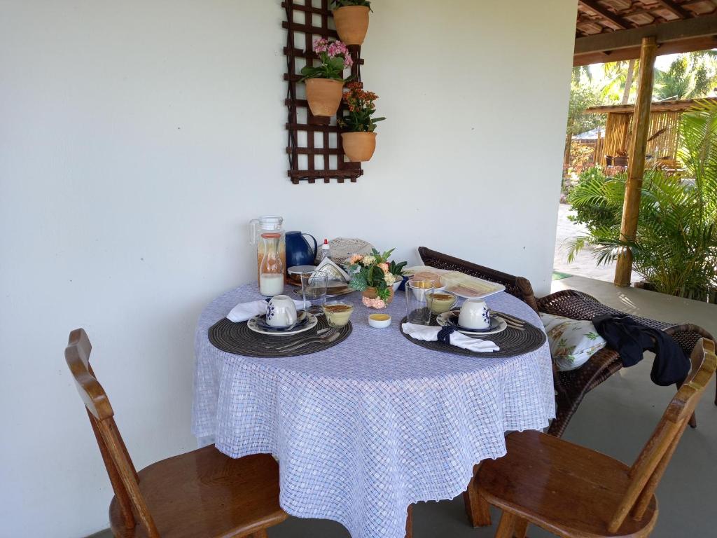 a table with a blue and white table cloth on it at Recanto Verde - Praia de Santo Antônio in Diogo