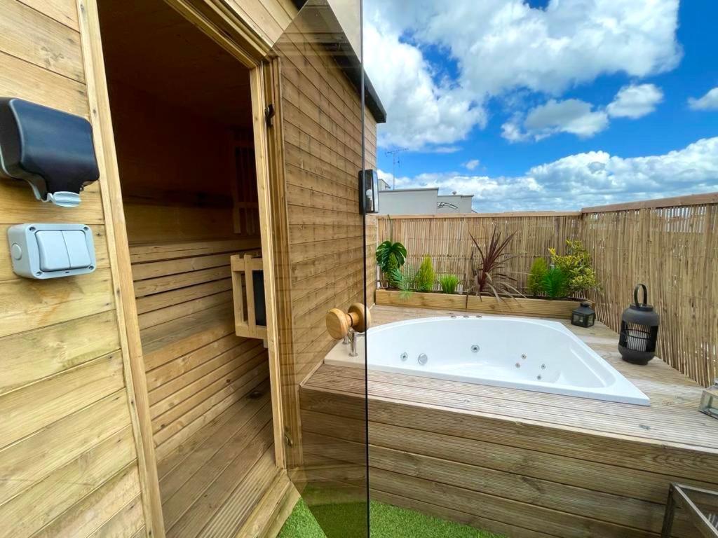 uma casa de banho com banheira num quintal em 2 Bedroom Roof Terrace SPA with Sauna plus Jakuzzi and Outdoor Cinema em Londres