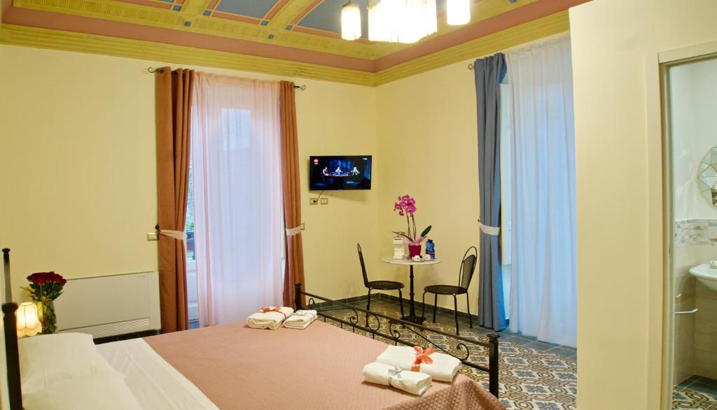 pokój hotelowy z łóżkiem i stołem z krzesłami w obiekcie Domus Aurea w mieście Montalbano Elicona