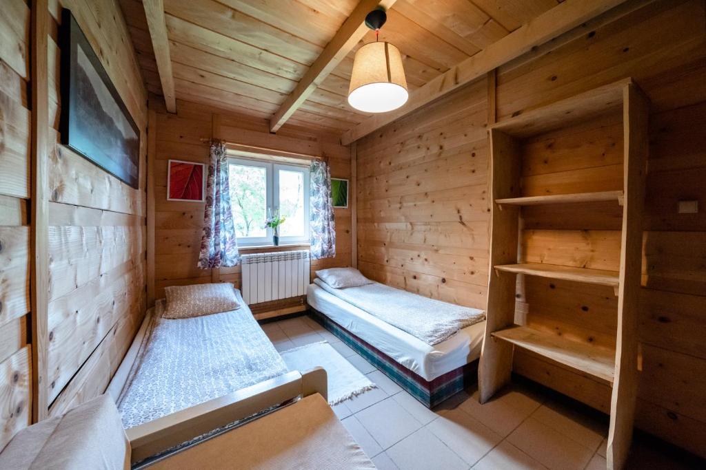 a room with bunk beds in a wooden cabin at Zagroda Chryszczata in Smolnik