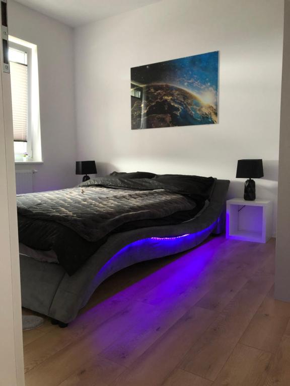 a bedroom with a bed with purple lights on the floor at Bliżej nieba in Jelenia Góra