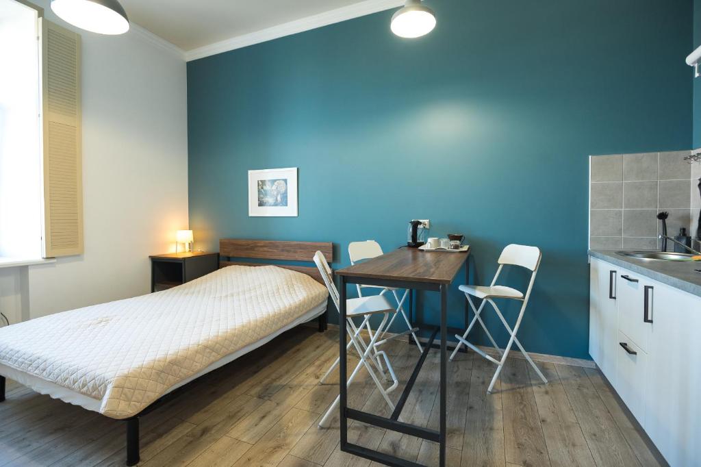 Cet appartement comprend une chambre avec un lit et une table ainsi qu'une cuisine. dans l'établissement апарт-готель у Кірхи, à Odessa