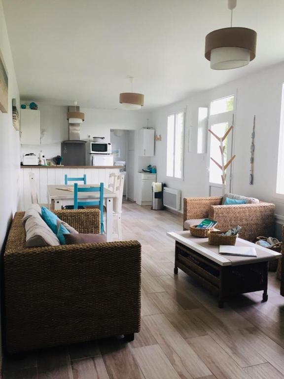 un salon avec un canapé et une table dans l'établissement La Longère à la Mer 6 pers 3 chambres grand jardin clôt a Fort-Mahon-Plage, à Fort-Mahon-Plage