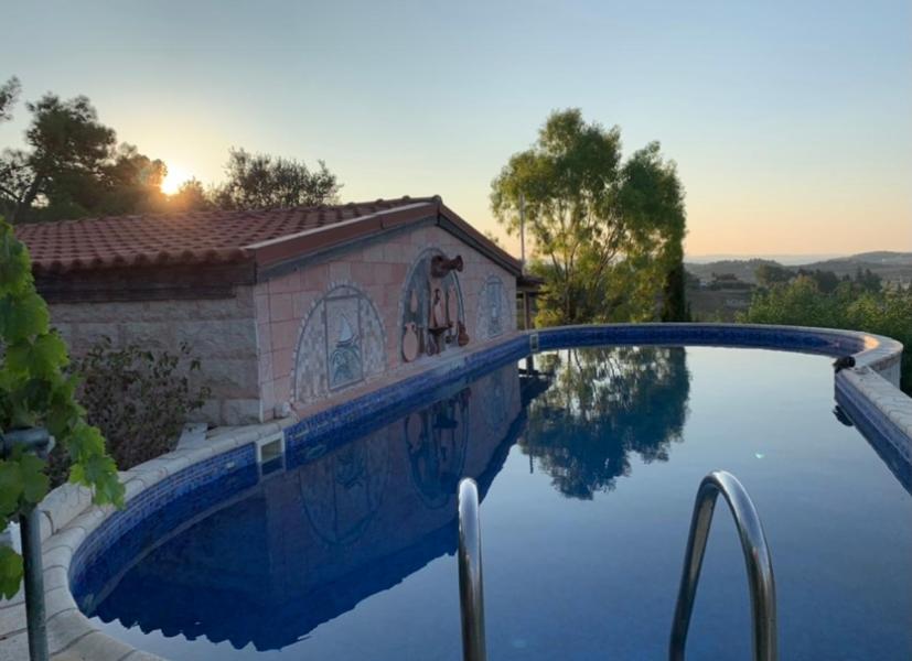 a swimming pool with a reflection in the water at Cosmema House 1 Hot tub and swimming pool villa in Stroumbi