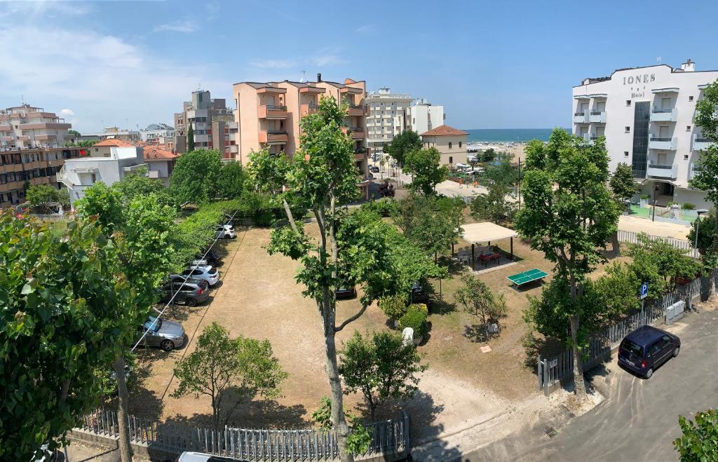 un parco alberato e auto parcheggiate in città di Hotel Del Vecchio a Rimini