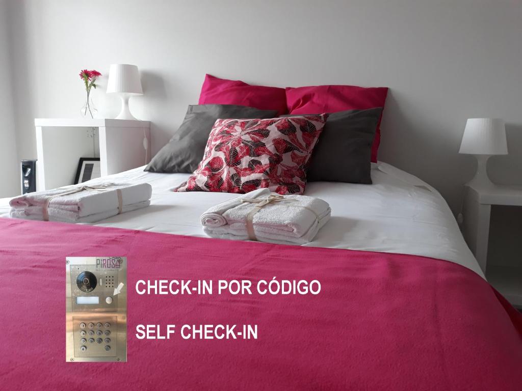 a bedroom with a bed with a pink blanket at Casa Pirosa in Aveiro