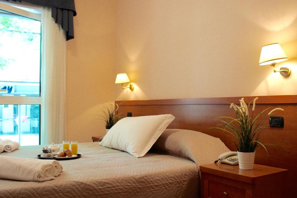 una camera d'albergo con un letto e un vassoio di cibo sopra di Depandance Hotel Jole a Cesenatico