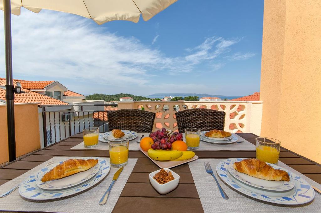 a table with food and fruit on a balcony at House Kovacevic in Makarska