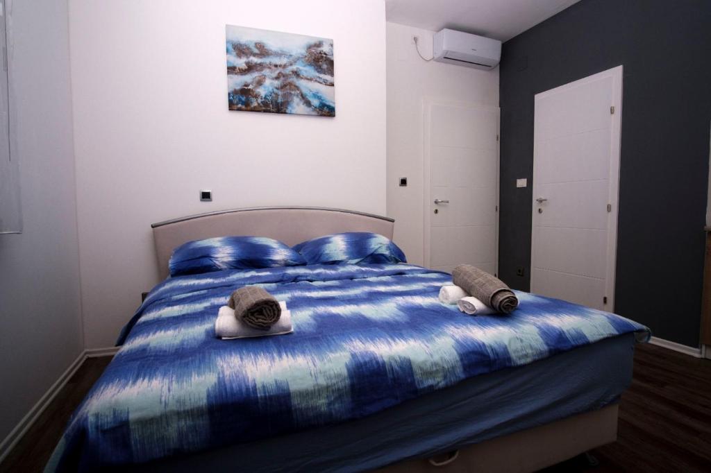 Un dormitorio con una cama azul con sombreros. en Ana ROOMS, en Ljubuški