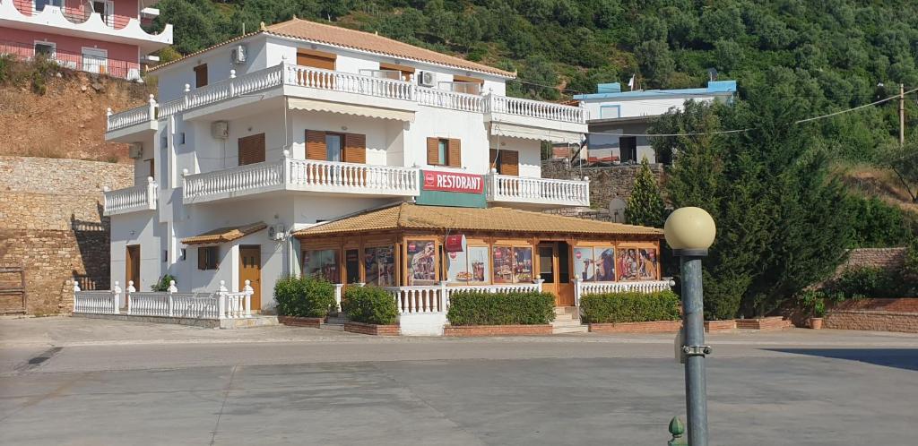 un gran edificio blanco con balcón en una calle en Hotel Lagjini, en Lukovë