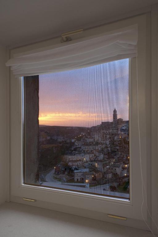 a window with a view of a city at Santa Cesarea Residence Luxury Suite - La vetta del Sasso Barisano in Matera