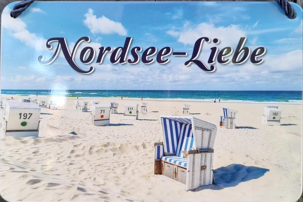 une photo d'une plage avec des chaises et l'océan dans l'établissement Nordsee Liebe - Hüttenzauber für 2 Personen, à Schortens
