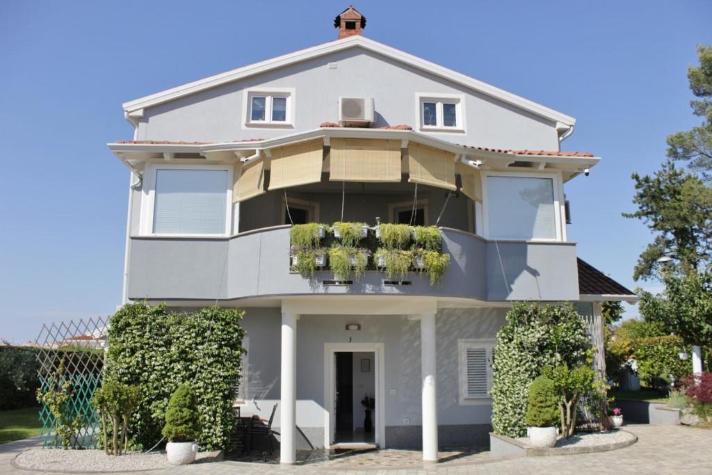 a white house with plants on the front at Apartments Titonel in Savudrija