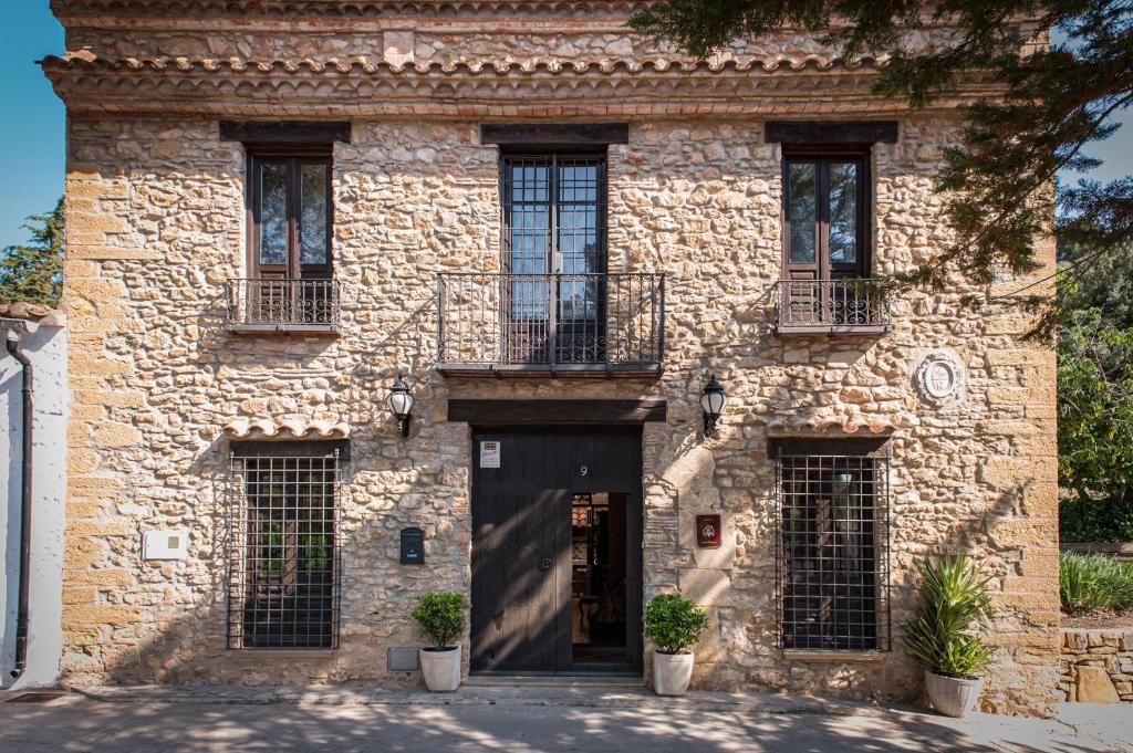 a stone building with a black door and windows at Casa rural dels Hospitalaris in Traiguera