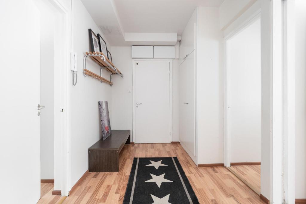 a hallway with white walls and a black rug with stars at City Star in Jyväskylä