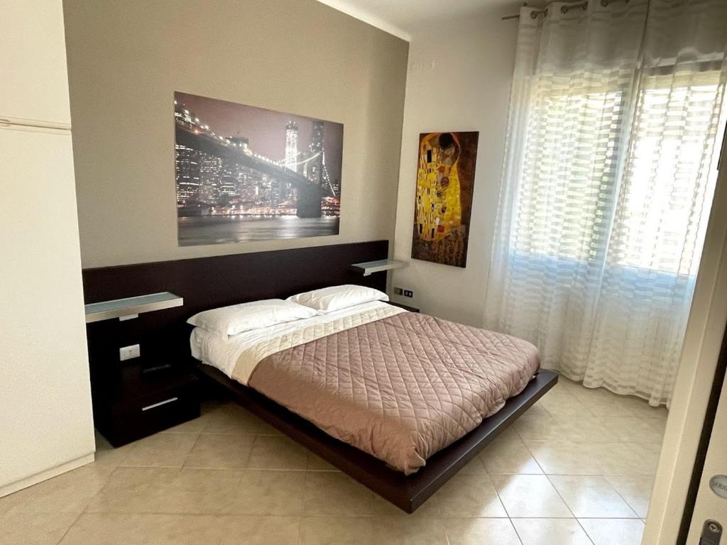 Casa Rosetta Affittacamere في ليسي: غرفة نوم بسرير ودهان على الحائط