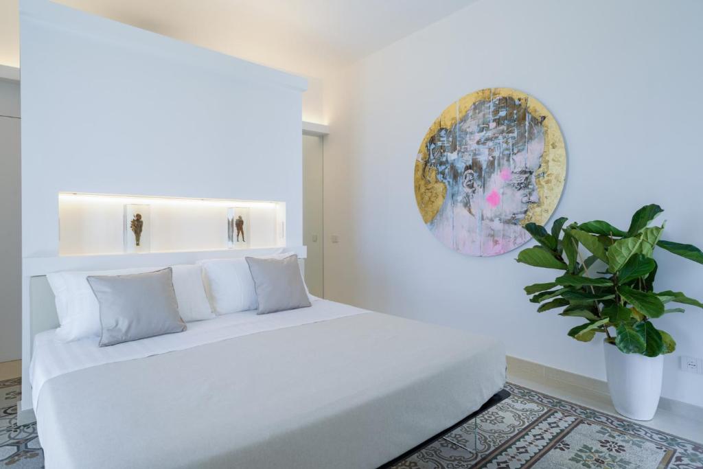 a bedroom with a white bed with a potted plant at Sopramonte Exclusive Rooms in Capri