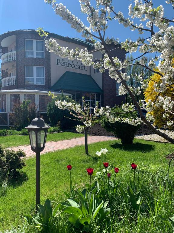 un parque con flores y una luz de la calle frente a un edificio en Renesance Hotel en Zelenogradsk