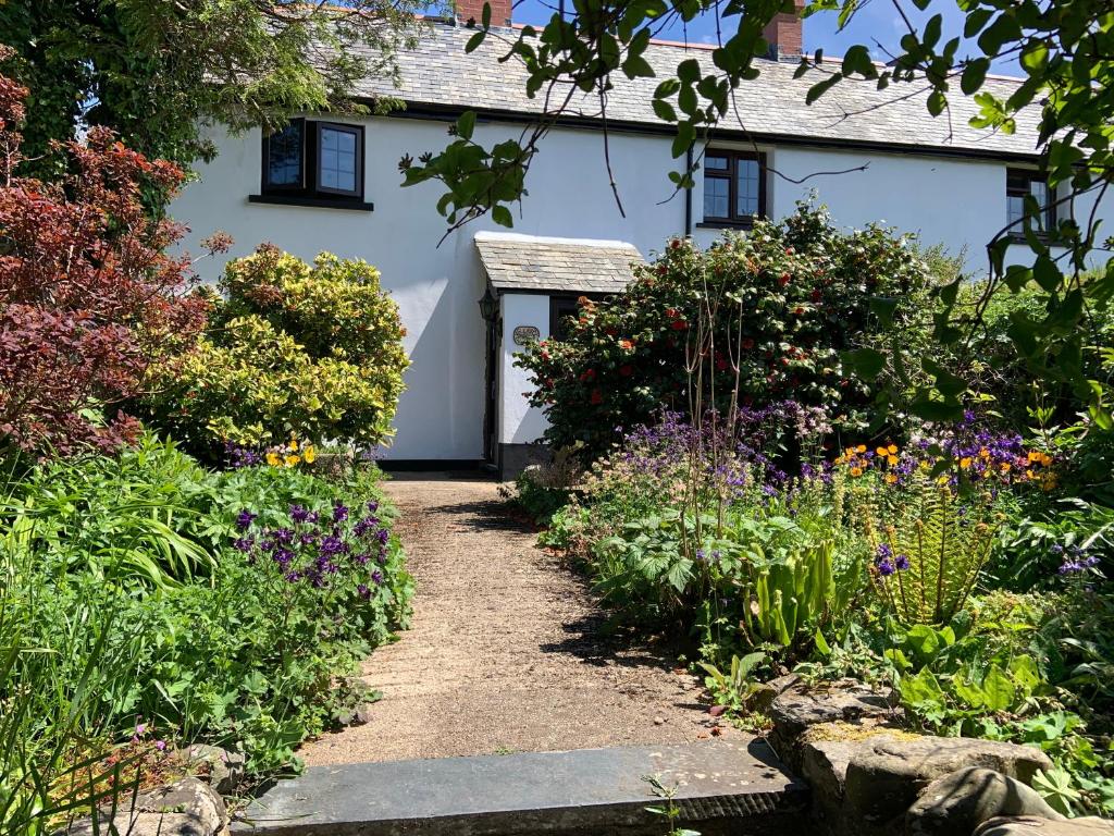 ein weißes Haus mit einem Garten davor in der Unterkunft Slerra Hill Bed and Breakfast, Clovelly in Bideford