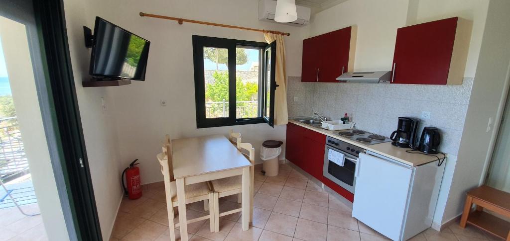 a small kitchen with a small table and a stove at Sivota Apartments in Syvota