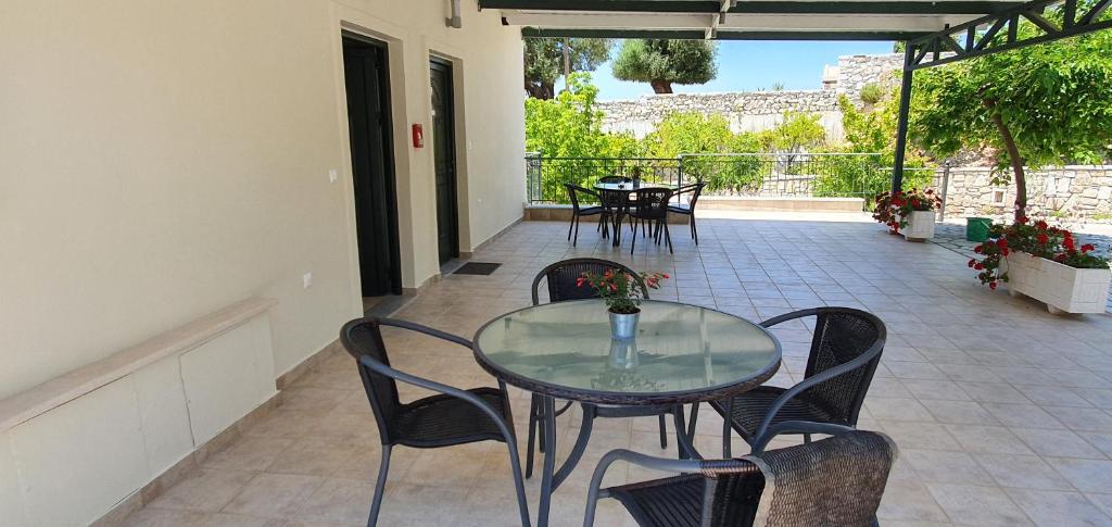 a glass table and chairs on a patio at Sivota Apartments in Syvota