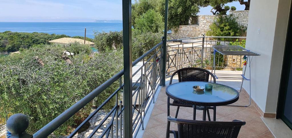 a balcony with a table and chairs and the ocean at Sivota Apartments in Syvota