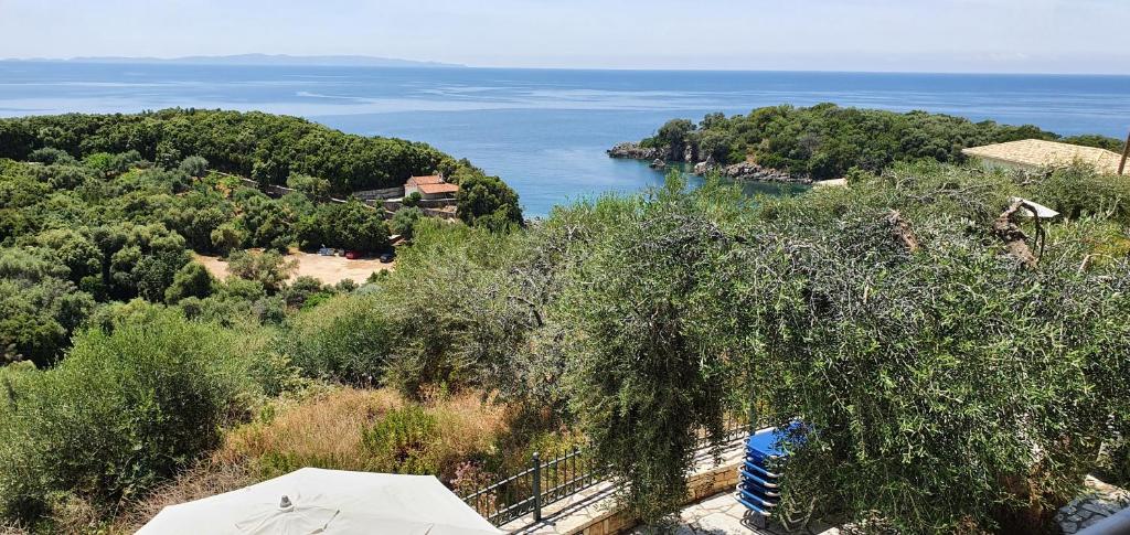a view of the ocean from a hill with an umbrella at Sivota Apartments in Syvota