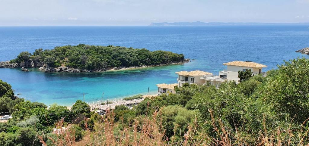 a house on a hill next to a body of water at Sivota Apartments in Syvota