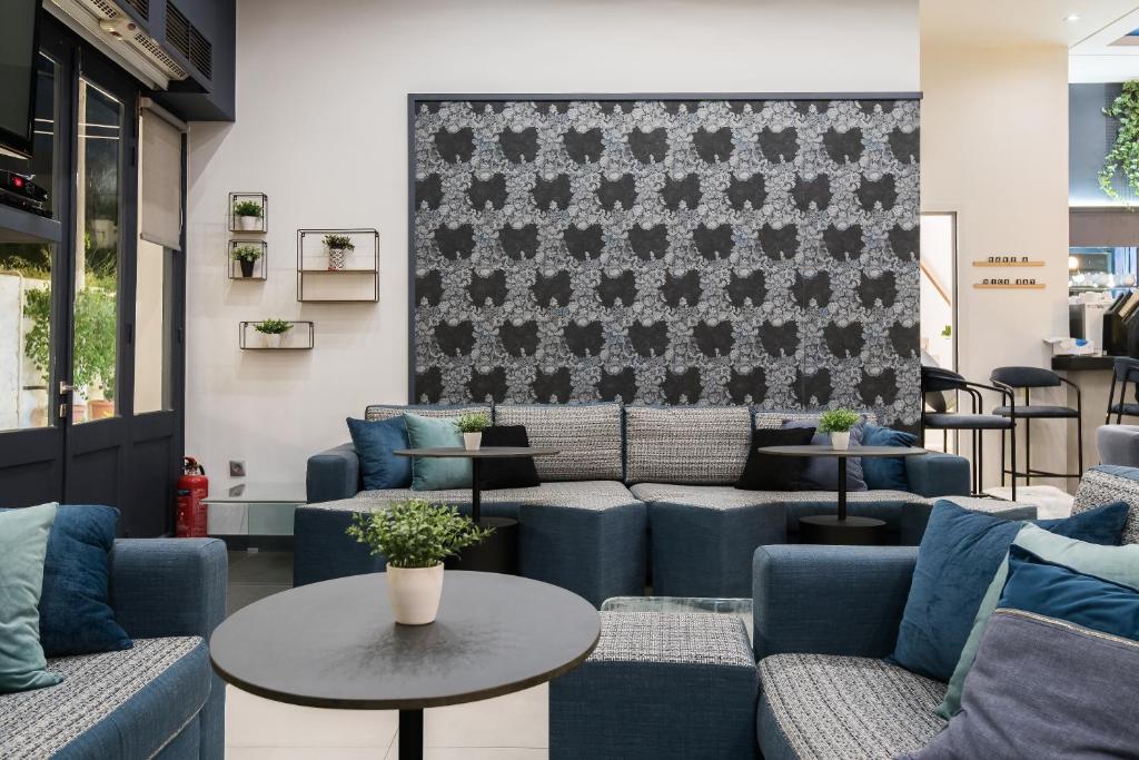 a waiting room with blue couches and a table at Klimis Hotel in Spetses