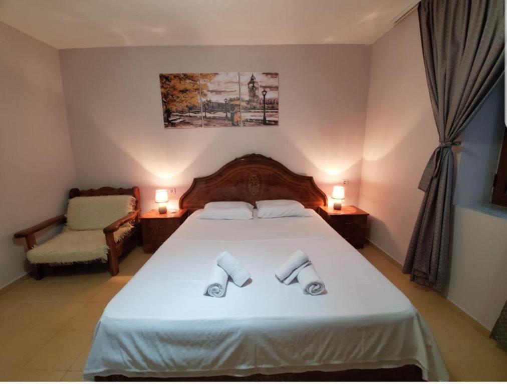 a bedroom with a bed with two towels on it at Vila Emilio in Udënisht