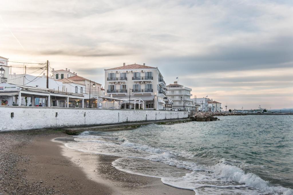 a view of a beach with buildings and the water at Klimis Hotel in Spetses