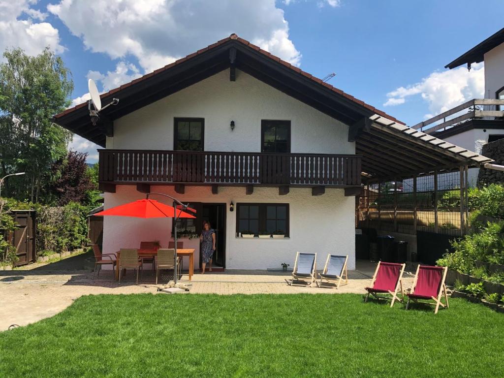 a house with chairs and a table in the yard at Ferienhaus am Hocheck in Oberaudorf