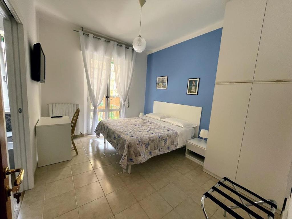 sypialnia z łóżkiem i niebieską ścianą w obiekcie Casa Rosetta Affittacamere w mieście Jesi