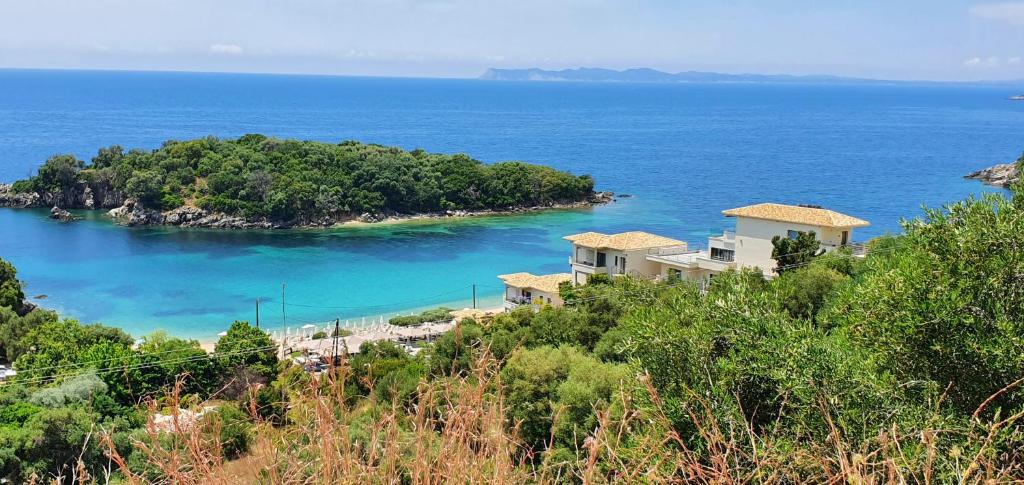 a house on a hill next to a body of water at Sivota Apartments in Syvota