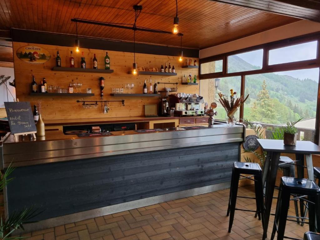 a bar in a restaurant with a view at Hotel Le Beau Site in Auris