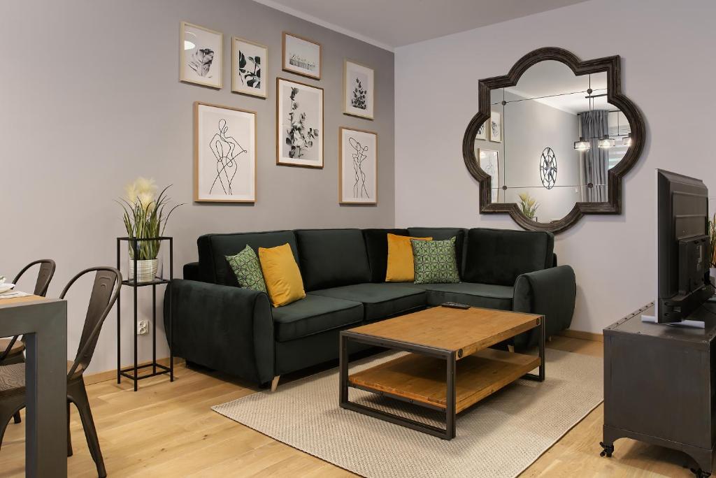 a living room with a green couch and a mirror at Zentrum II Apartament IMPERO z Parkingiem in Poznań