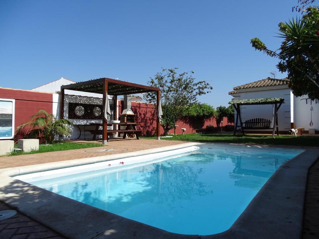 a swimming pool in a yard with a gazebo at Samadhi Home in Chiclana de la Frontera