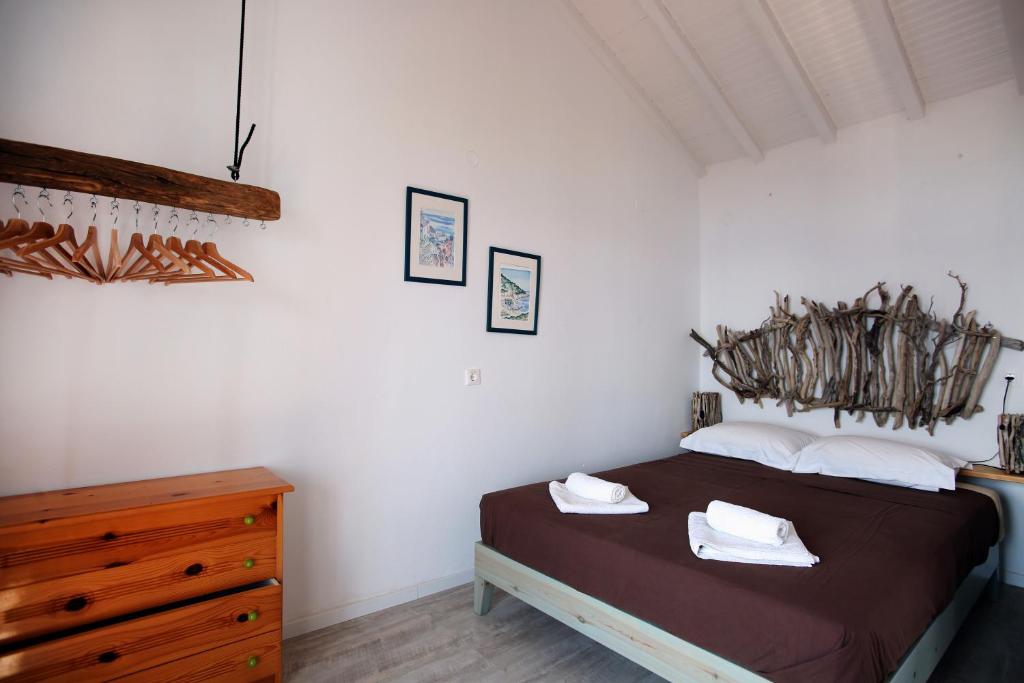 a bedroom with a bed and a wooden dresser at Christou Homes in Steni Vala Alonissos