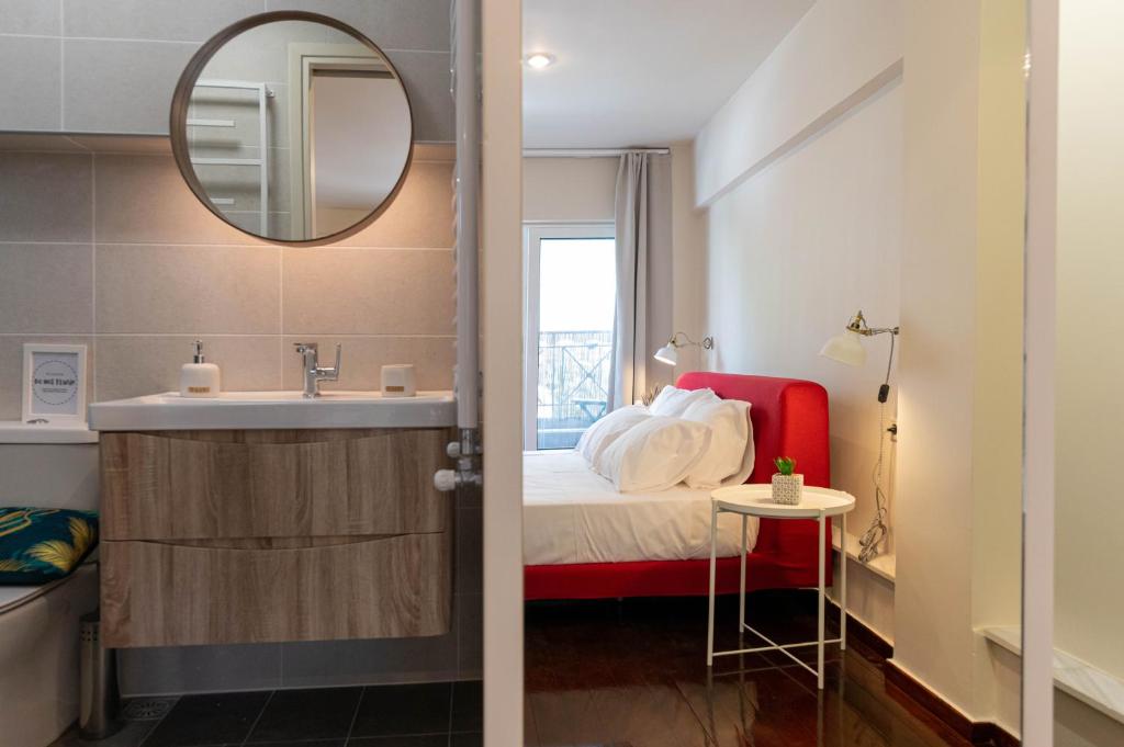 uma casa de banho com uma cama, um lavatório e um espelho. em Scala_Apartment em Kalamata