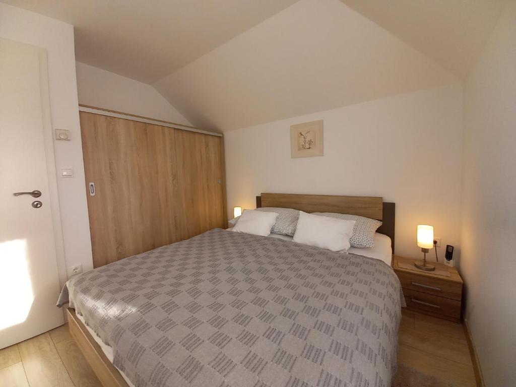 a bedroom with a large bed and two lamps at Laura Luxury Apartman Gyenesdiás in Gyenesdiás