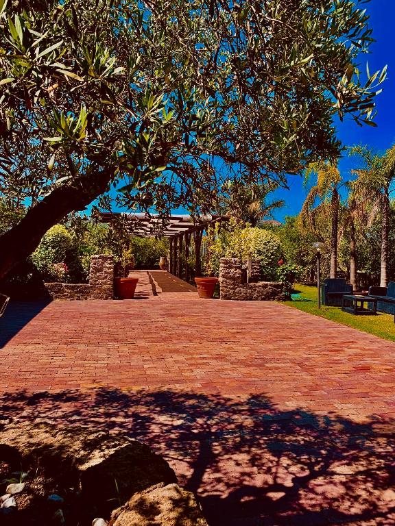 a brick walkway with a tree in a park at Agriturismo le tre stelle in Paestum