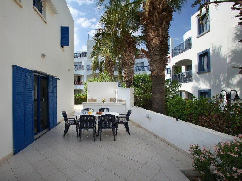 a patio with a table and chairs and a building at Villa Julie in Protaras
