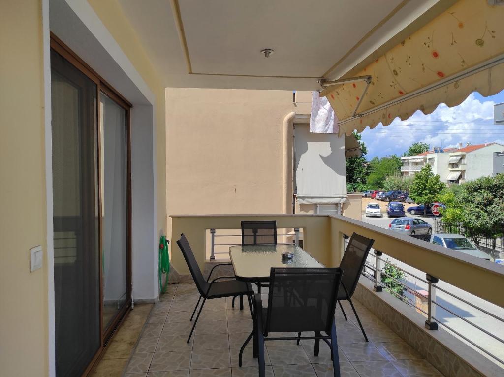 eine Terrasse mit einem Tisch und Stühlen auf dem Balkon in der Unterkunft Elena House in Néa Péramos