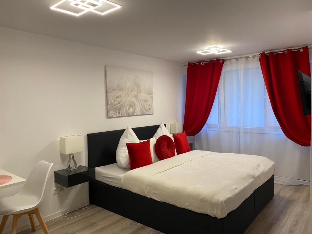 a bedroom with a bed with red curtains at Prime Host Sophie Apartments in Karlsruhe