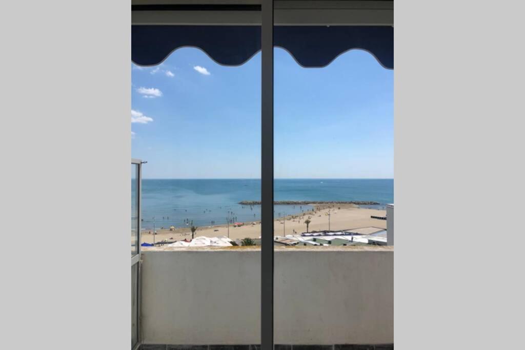 a view of a beach from a window at NEW YORK in La Grande-Motte