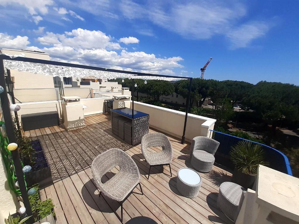 a deck with chairs and tables on a balcony at confortable appartement T2 in La Grande-Motte