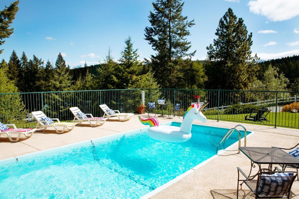 a swimming pool with a inflatable unicorn float in the middle at Timbers Motel in Bigfork